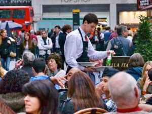 Waiter working in crowded outdoor restaurant