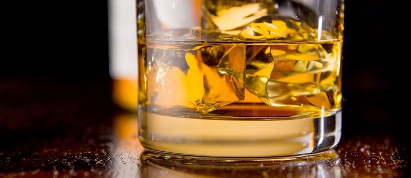 Scotch Whiskey on the rocks in a glass amber