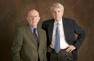 Two men dressed in nice suits stand for a portrait