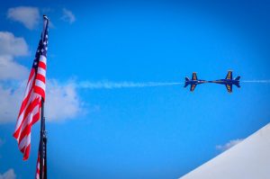 Photo of flag and jets flying over