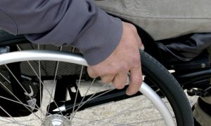 Closeup of a hand on a wheelchair.