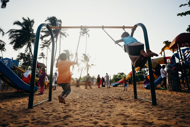 two kids on swingset on playground