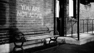 Empty bench in front of brick wall