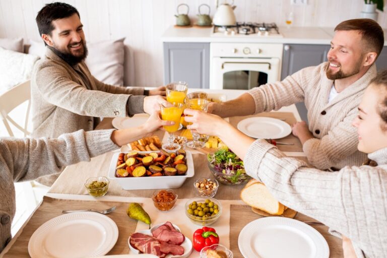 Four people with glasses of orange juice over a breakfast table