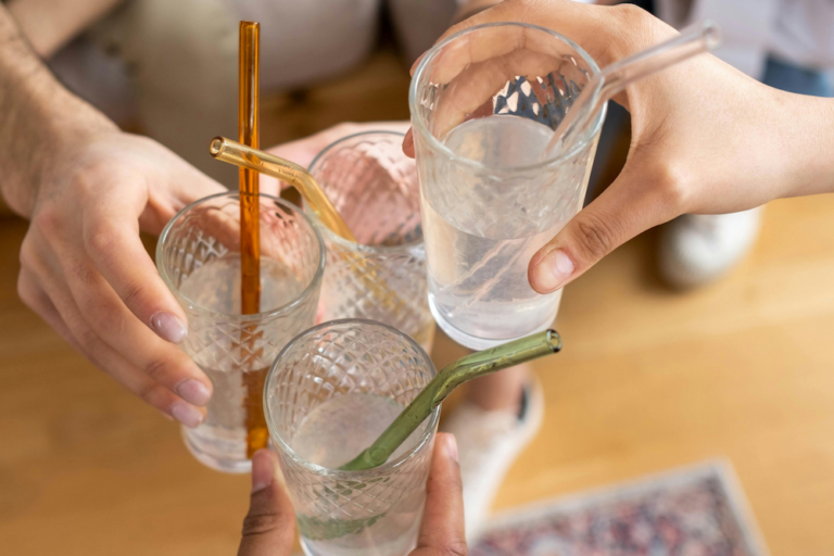 Four glasses with water and glass straws