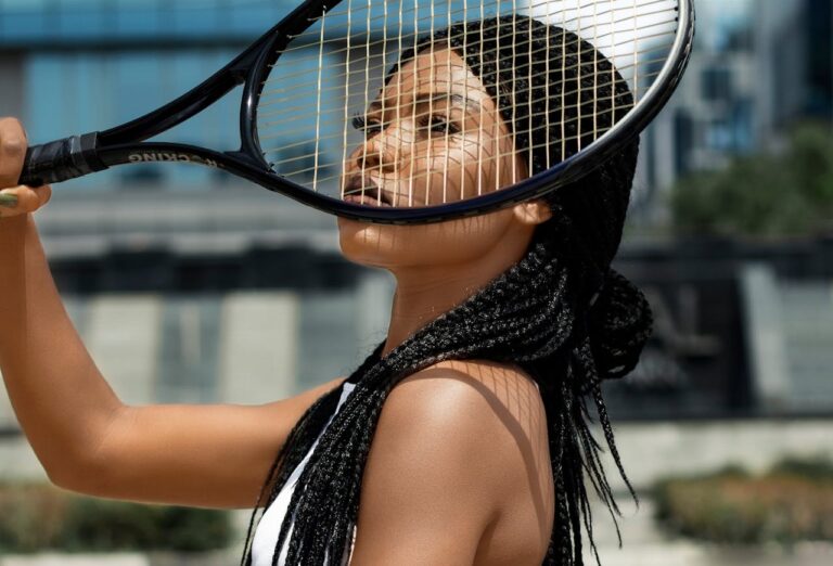 Tennis player holding racket up to her face