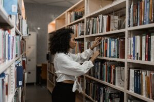 woman looking through library bookshelves