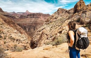 Woman with hiking backpack looking at mountains