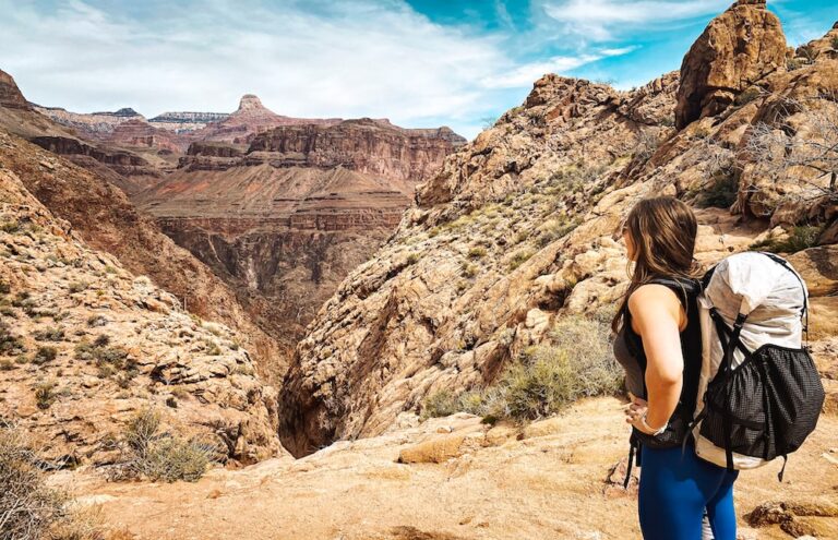 Woman with hiking backpack looking at mountains