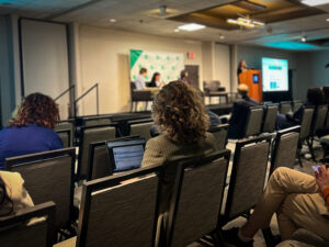 Woman taking notes on a computer during a panel session