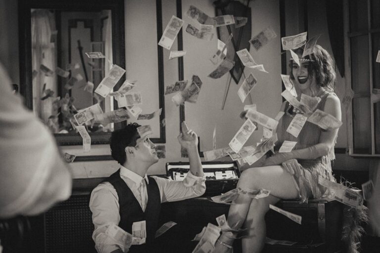 Couple by piano among flying money in twenties clothing