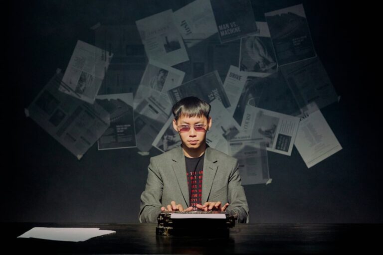 Man in gray suit typing on typewriter in dark room
