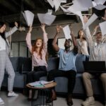 Group of coworkers throwing pieces of paper in the air in celebration