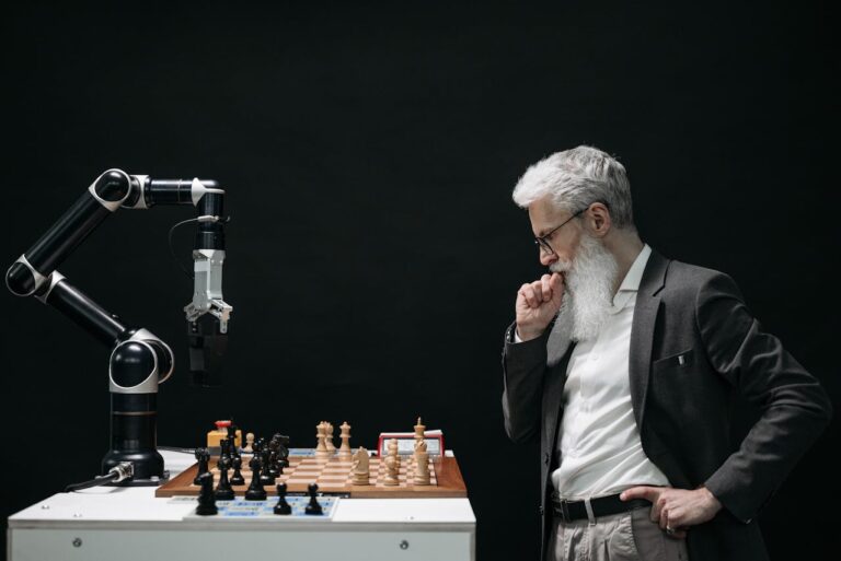 Elderly man thinking while looking at a chessboard across from robotic arm as his opponent