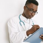 A doctor writing on a folder