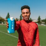 Athlete holding up product to camera on the field