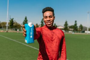 Athlete holding up product to camera on the field