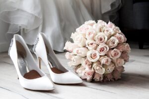 White wedding heels and bouquet of pale pink flowers