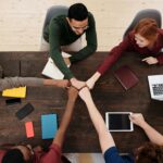 Group of colleagues fist-bumping over a table