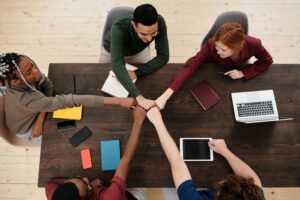 Group of colleagues fist-bumping over a table