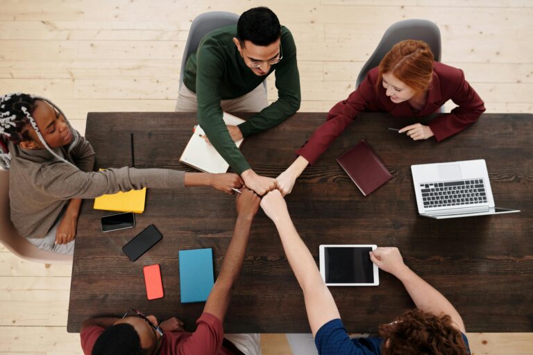 Group of colleagues fist-bumping over a table
