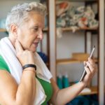 Woman looking at device while checking her own pulse