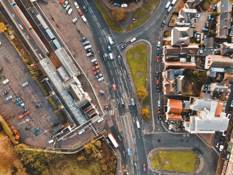 Aerial view of Cars driving on road in suburb area on sunny day