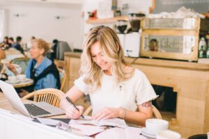 Woman Drawing an Art on a Book in a cafe