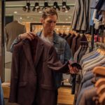 A Man Looking at a Suit Jacket in a Clothing Store