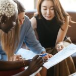 Attentive diverse businesswomen working on contract