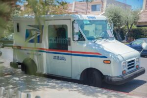 United States Postal Service van parked on a sunny street in Los Angeles, CA.