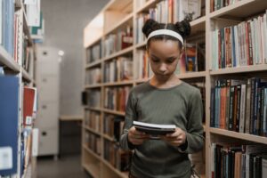 Young girl looking at a book in the library