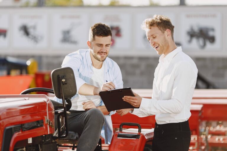 A business man getting a signature from a customer sitting on a tractor