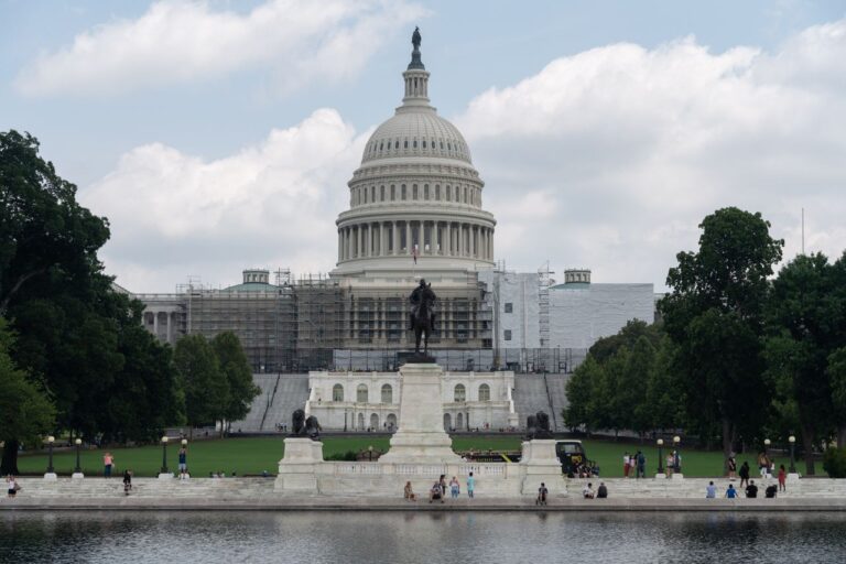 US Capitol with dome, statue, and reflecting pool on a sunny day in Washington, D.C.