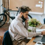 A young male freelancer working on a laptop in a stylish office.