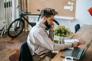 A young male freelancer working on a laptop in a stylish office.