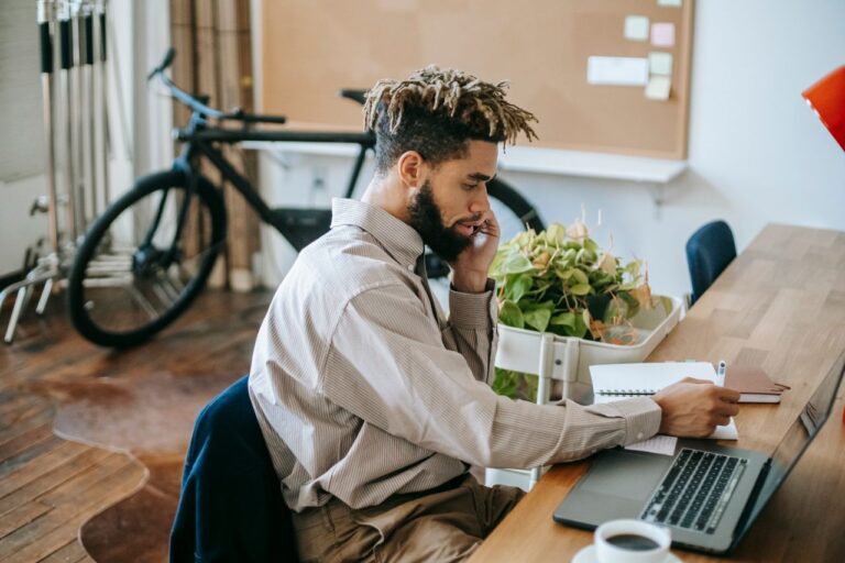 A young male freelancer working on a laptop in a stylish office.
