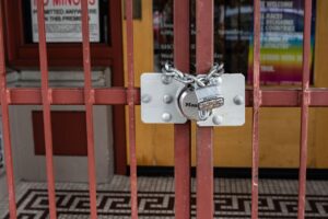 Iron gate with a padlock securing a closed entrance.
