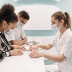 A healthcare professional in a medical setting assists patients at a clinic desk, emphasizing care and teamwork.